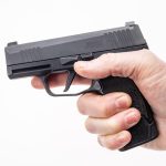 MTX 365 installed onto magazine and into pistol. Shown with hand gripping pistol facing left. Hand has ideal P365 pinky placment