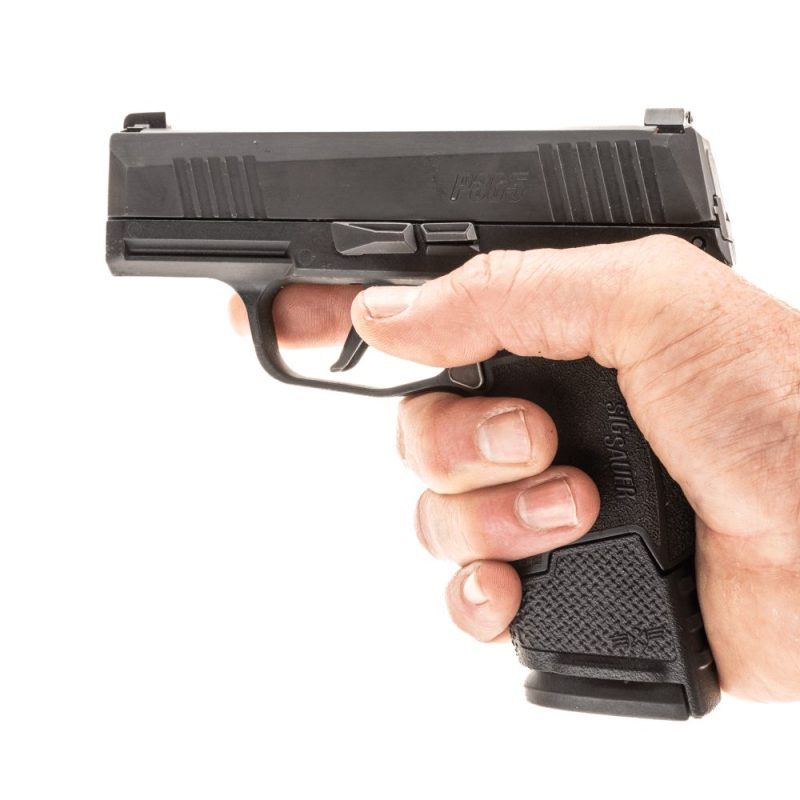 P365 pistol in hand with extended magazine facing left giving support